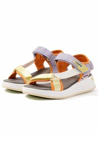 Sandalias de tela moradas y amarillas con correas ajustables, detalles en naranja y una suela blanca acolchada. Diseño ligero con una estética moderna.