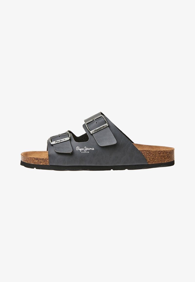 Mustad musta sandaal, millel on kaks metallist lukku, korkvaht midsole ja tekstureeritud põhi. Ülemisel rihmal on logo detail.