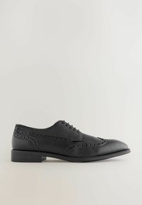 Czarne skórzane buty do garnituru z teksturowanym wierzchem, detalami w stylu brogue i okrągłym noskiem. Posiadają płaską gumową podeszwę i tradycyjne sznurowanie.
