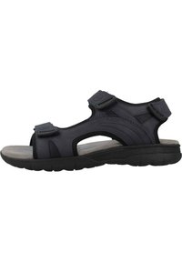 Sandalia negra para hombre con correas ajustables de Velcro, plantilla acolchada y suela de goma texturizada para un agarre y comodidad óptimos.