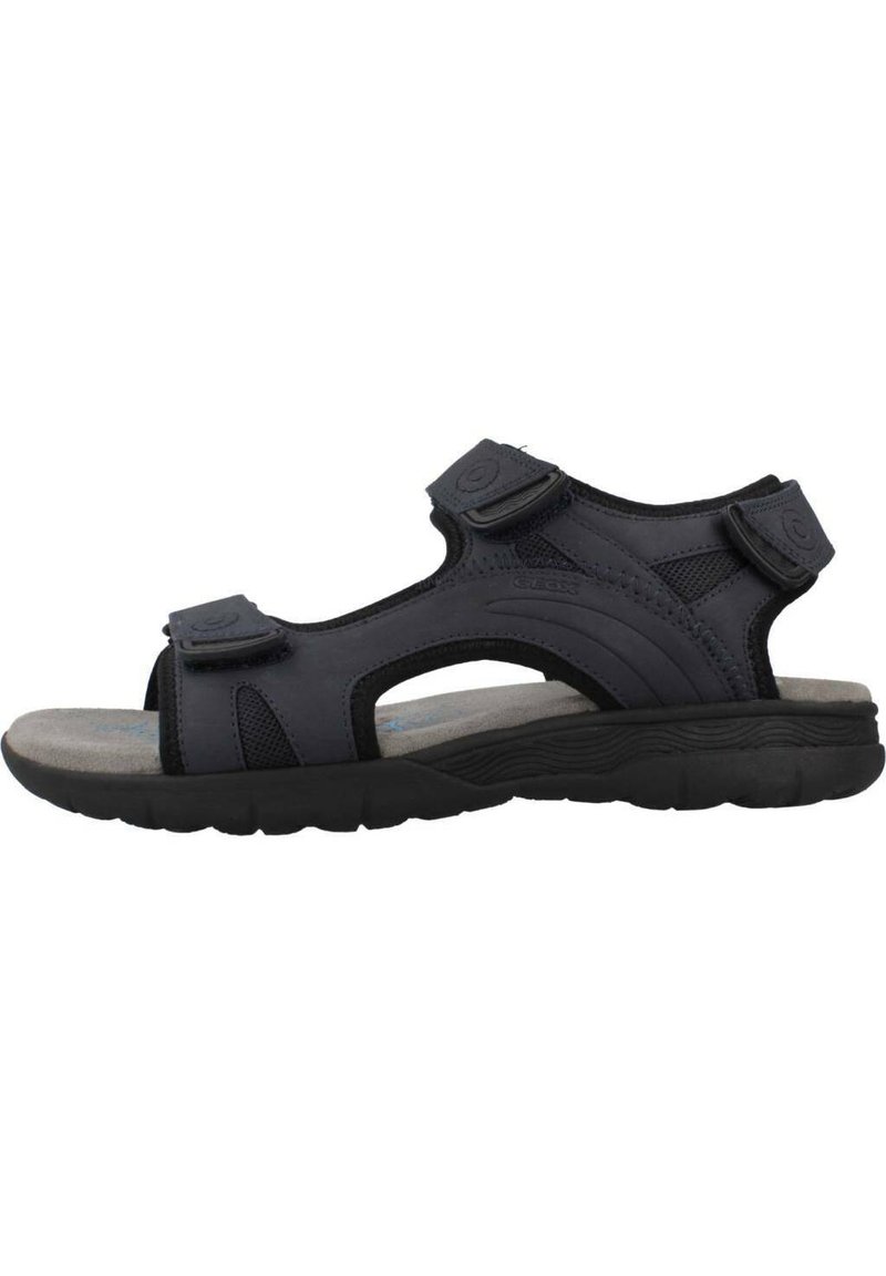 Sandalia negra para hombre con correas ajustables de Velcro, plantilla acolchada y suela de goma texturizada para un agarre y comodidad óptimos.