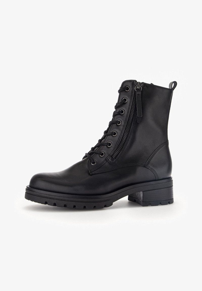 Bottine noire en cuir à lacets avec fermeture éclair latérale, semelle épaisse et petit talon carré sur fond blanc.