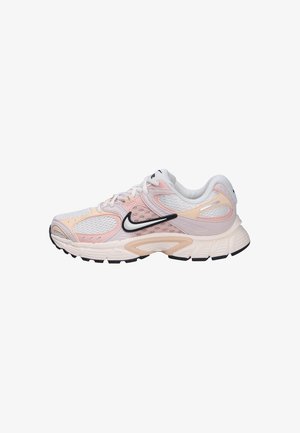 Chaussure de running Nike blanche et rose pâle avec un swoosh noir, dessus en mesh, semelle rembourrée et lacets, vue de profil sur fond blanc.