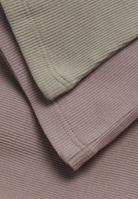Zwei gerippte Stoffmuster in Olivgrün und Staubrosé, die eine feine Textur und sauberen Stich entlang der Kanten zeigen.