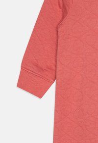 Korale T-shirt z długim rękawem, z teksturowanym wzorem serca, prążkowymi mankietami i gładkim wykończeniem. Mieszanka bawełny o luźnym kroju.