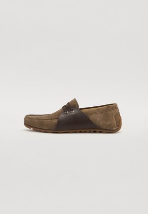Mocassini din suede maro, cu un accent din piele maro mai închis și două găuri pentru șireturi. Design cu profil redus și talpă flexibilă din cauciuc.