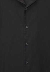 Camicia nera con bottoni in tessuto leggero, caratterizzata da un colletto classico e diversi bottoni sul davanti, con una texture liscia.