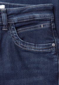 Przednia kieszeń ciemnoniebieskich jeansów z widocznym przeszyciem, kieszonka na monety, szlufka na pasek i mały metalowy nit.