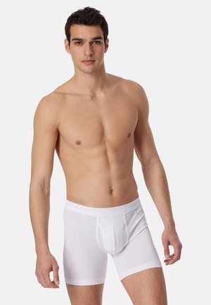 Boxer bianchi in cotone con una texture liscia, vita elastica e una tasca centrale. Il design consente comfort e facilità di movimento.