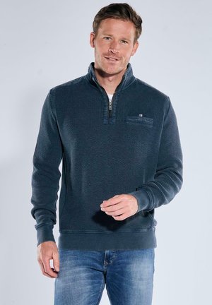 Marineblauer Reißverschluss-Hoodie aus strukturiertem Stoff, mit hohem Kragen, gerippten Bündchen und einem kleinen Brusttaschen-Detail.