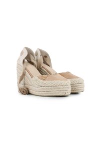 Zapatos de cuña de esparto beige con suela de yute trenzado, acentos de ante y correas de tela que se envuelven alrededor del tobillo. Presenta un detalle de logo.