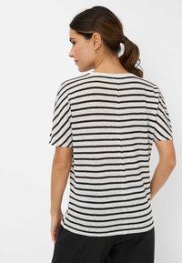 Stribet t-shirt i grå og sort, med korte ærmer og rund halsudskæring. Lavet af blødt stof med en afslappet pasform.