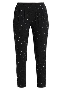 Zwarte broek van rekbare stof, met een geplooide voorkant en een patroon van kleine witte driehoeken erdoorheen. Aangesneden, taps toelopende pasvorm.