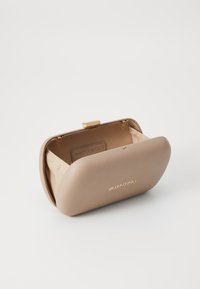 Bolso de mano de cuero beige con un cierre en tono dorado, forma redondeada y un forro de satén suave que presenta una etiqueta de marca en su interior.