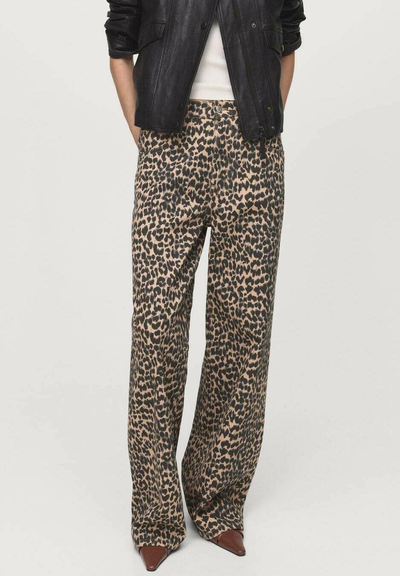Béžové a čierne nohavice širokého strihu s leopardím vzorom, vyrobené z hladkého materiálu a s vysokým pásom. Doplnené o hnedé špicaté topánky.