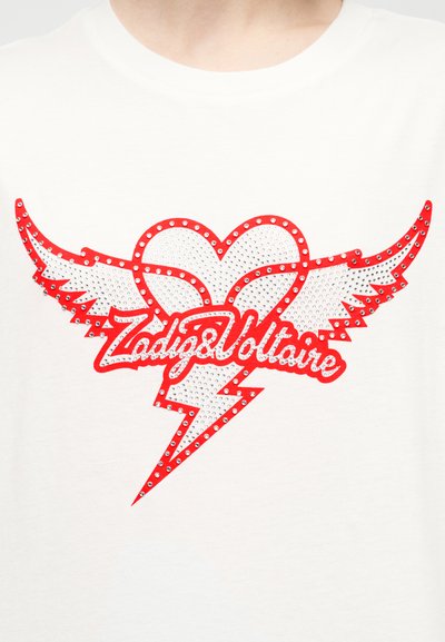 Λευκό T-shirt με κόκκινη και ασημένια διακοσμημένη με στρας σχεδίαση καρδιάς με φτερά και κεραυνό, με την επωνυμία "Zadig&Voltaire".