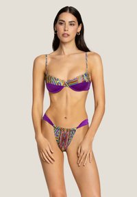 Bikini viola con motivi tribali colorati, dotato di un top strutturato con spalline regolabili e un slip a vita bassa con fianchi a taglio.