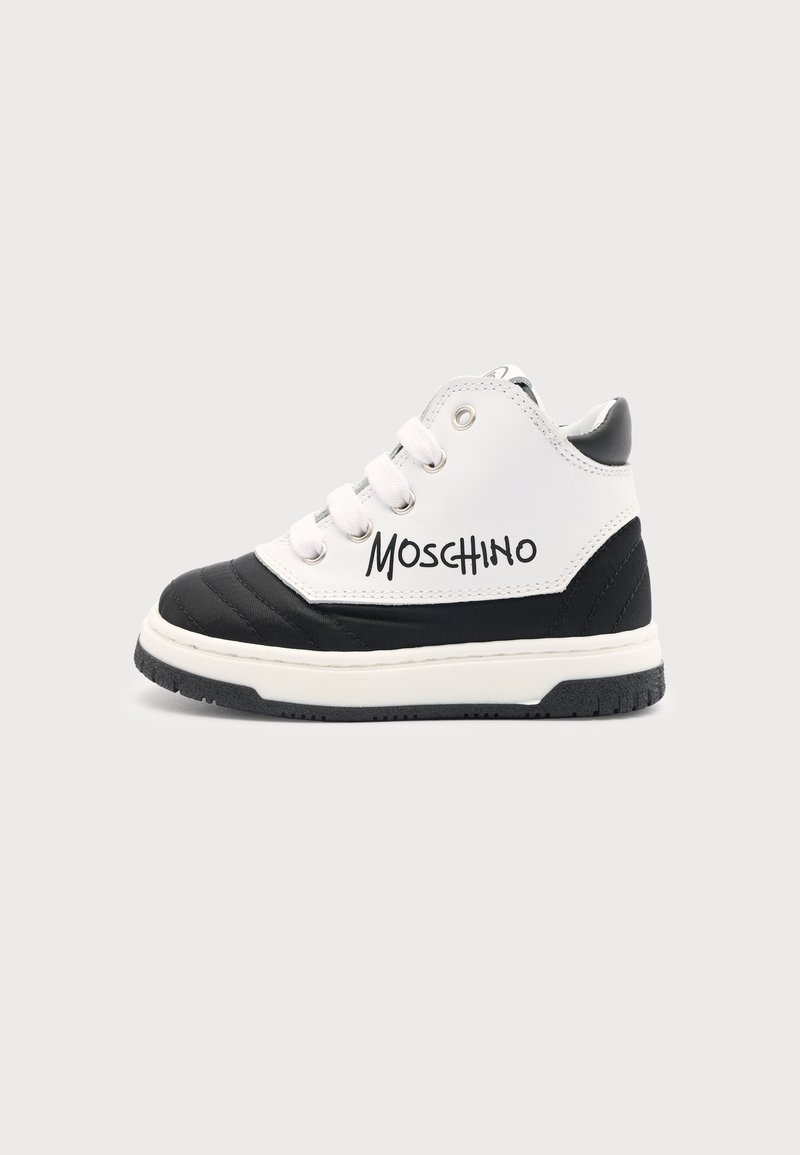Μαύρο και άσπρο ψηλό αθλητικό παπούτσι Moschino με λευκά κορδόνια και παχιά σόλα, εμφανίζεται από το πλάι σε απλό φόντο.