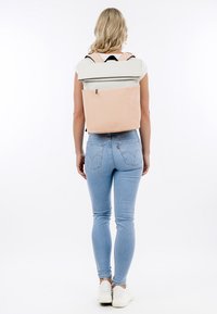 Rückansicht eines zweifarbigen Rucksacks mit einem beigen Boden und einem hellgrauen Deckel, verstellbaren Trägern und einer Reißverschlusstasche auf der Rückseite.