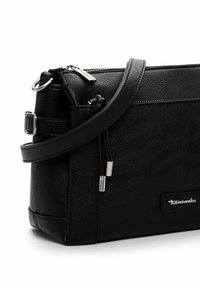 Black leather crossbody bag featuring a textured surface, adjustable strap, zip closure, and silver-tone hardware accents.
