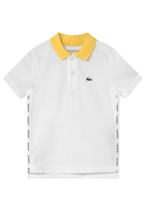 Hvid kortærmet polo med gul krave, to knapper, sidetape med teksten "Lacoste" og lille grønt krokodillelogo på brystet.