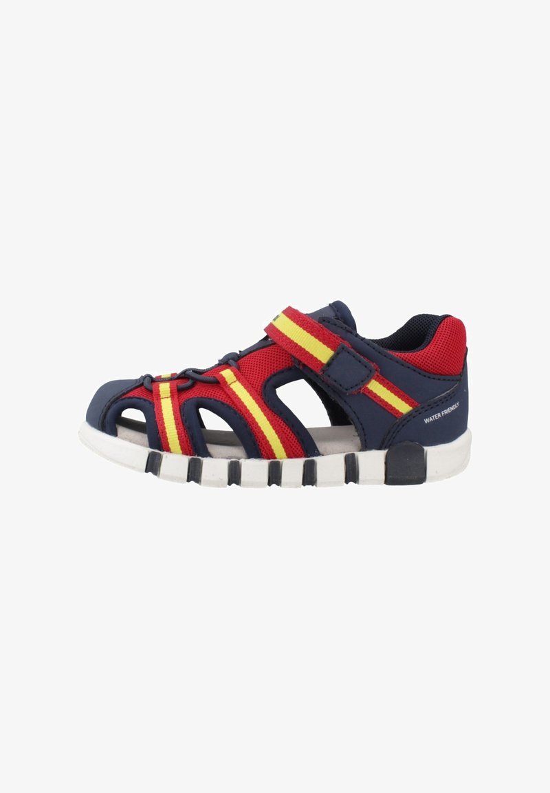 Sandale pour enfants bleu marine, rouge et jaune, adaptée à l'eau, avec bout fermé, bride en Velcro et semelle blanche à motifs.
