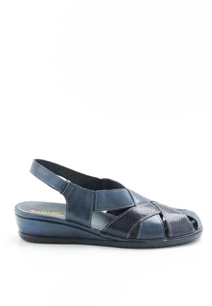 Dunkelblaue Leder-Sandale mit geschlossenem Ferse und offenem Zehenbereich. Texturierte Akzentpanelen und gestickte Details. Niedriges Keilabsatz-Design.