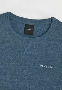 Granatowa koszulka z krótkim rękawem wykonana z miękkiej mieszanki bawełny, z okrągłym dekoltem i białym logo "DIVERSE" z przodu.