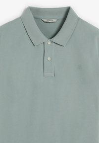 Tricou polo albastru deschis din material texturat, cu guler clasic, trei nasturi și un mic logo brodat pe piept.