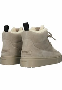 Beżowe zamszowe sneakersy typu high-top z teksturowanym futerkiem wewnątrz, płaską beżową podeszwą i czarną pętlą. Logo Blackstone na pięcie.