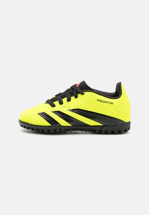 Zapatos de fútbol amarillos con acentos negros, parte superior sintética texturizada, diseño con cordones y suela de goma, que presenta el logo "Predator".