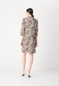 Luipaardprint jurk met een getailleerde pasvorm, ¾ mouwen en een centrale ritssluiting aan de achterkant. Gemaakt van zachte stof, afgewerkt met een gladde textuur.