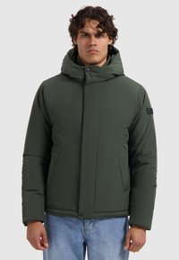 Donkergroene geïsoleerde jas met een hoge kraag en capuchon, uitgerust met zijzakken en een knoopsluiting. Gladde, matte textuur overal.