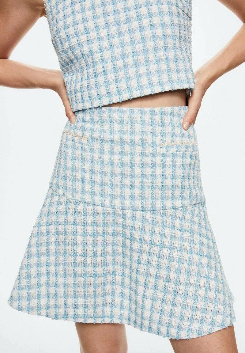 Completo composto da top e gonna a quadretti leggeri blu e bianchi, caratterizzato da una trama tessurizzata e due tasche frontali sulla gonna.