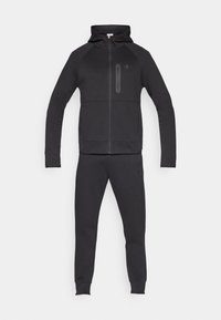 Tuta da ginnastica nera composta da felpa con cappuccio e zip frontale con tasca anteriore e pantaloni affusolati abbinati, realizzati in tessuto morbido e strutturato.