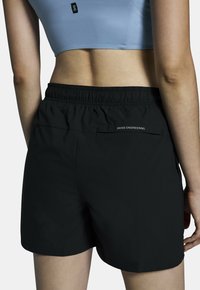 Svarta sportshorts med resårmidja, med en liten bakficka och texten "SWISS ENGINEERING" i vit färg.