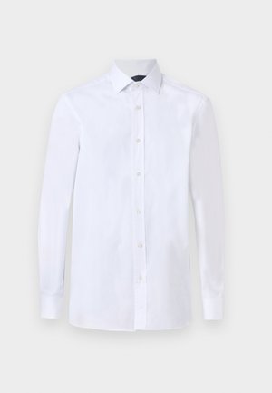 Camisa blanca de hombre de manga larga con botones en la parte delantera y cuello puntiagudo, mostrada sobre un fondo liso.