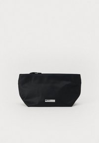 Μαύρη νάιλον θήκη με επίπεδο, στρογγυλεμένο πάτο, κλείσιμο με φερμουάρ και μεταλλικό λογότυπο. Λιτή υφή χωρίς ορατά σχέδια.