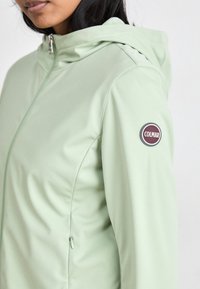 Világoszöld, húzózáras dzseki kapucnival, bal karján kerek Colmar logóval ellátva. Simas felismerhető textúrájú és szabott kialakítású.