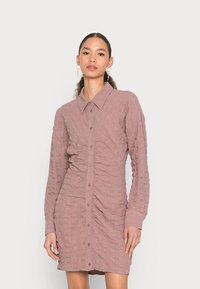 Vestido camiseiro de mangas compridas em tecido mauve texturizado, com frente abotoada, colarinho aberto e detalhes franzidos nas laterais.