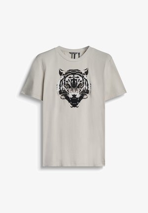 T-shirt in cotone beige chiaro con grafica di una tigre in bianco e nero sul davanti. Collo a giro, maniche corte e vestibilità casual.