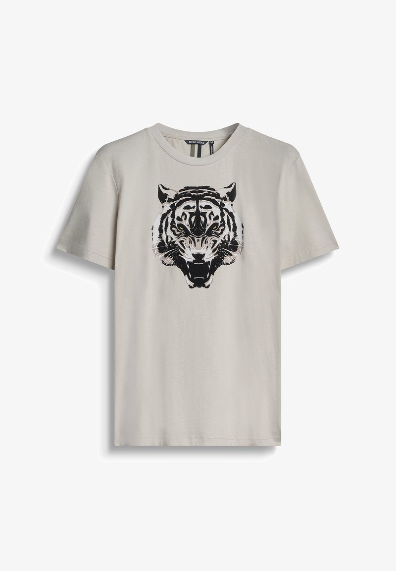 Camiseta de algodón color beige claro con un gráfico de tigre en blanco y negro en la parte frontal. Cuello redondo, mangas cortas y ajuste casual.