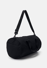 Borsa duffel nera, forma cilindrica, realizzata in tessuto resistente, dotata di doppie maniglie, di una tracolla regolabile e di un'apertura con zip.