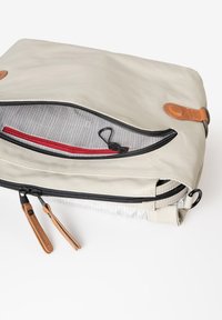 Borsa grigia chiara con zip e interno in tessuto caratterizzato da un motivo a griglia. Include una tasca rossa e dettagli in pelle marrone. Presenta diverse zip.