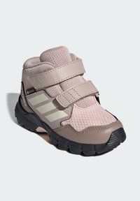 Bota de senderismo rosa y gris con parte superior de malla, dos correas de velcro, suela de goma y detalles texturizados, diseñada para actividades al aire libre.