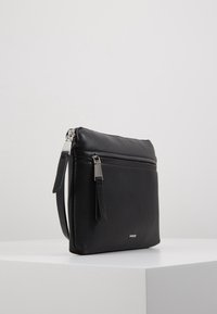 Bolso de cuero negro con textura granulada, que cuenta con un cierre de cremallera, un bolsillo frontal y acentos de metal en tono plateado.