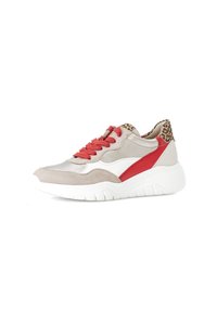 Beige en rode sportschoen met een suede buitenkant, witte accenten en panterprint op de hiel. Heeft een dikke, gestructureerde witte zool en rode veters.