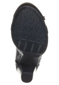 Svarta skor med en strukturerad gummisula med ett mönstrat yta, låg blockklack och detaljerad sidonätdesign.