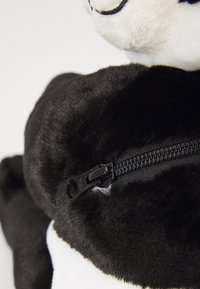 Animale di peluche in bianco e nero con una texture liscia, caratterizzato da una zip nera visibile sul retro.