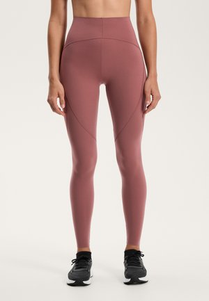 Legginsy z wysokim stanem w kolorze przybrudzonego różu, wykonane z elastycznego materiału o gładkiej strukturze. Cechują się detalami szwów oraz elastyczną talią.